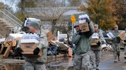 national guard members carry bottle water after hurricane sandy