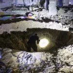 Members of Israel's Home Front Command and police forces inspect a crater left by an exploded projectile at a heavily-damaged school building in Israel's southern city of Gedera on October 1, 2024, after Iran launched a barrage of missiles at Israel in response to the killings of Lebanese Hezbollah leader Nasrallah and other Iran-backed militants. Reports said Iran fired between 150 and 200 missiles in the attack, the country's second on Israel after a missile and drone attack in April in response to a deadly Israeli air strike on the Iranian consulate in Damascus. (Photo by MENAHEM KAHANA/AFP via Getty Images)