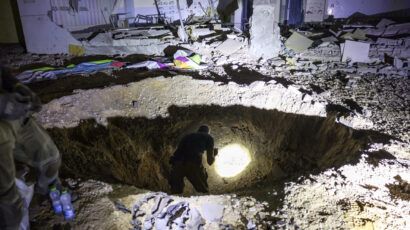 Members of Israel's Home Front Command and police forces inspect a crater left by an exploded projectile at a heavily-damaged school building in Israel's southern city of Gedera on October 1, 2024, after Iran launched a barrage of missiles at Israel in response to the killings of Lebanese Hezbollah leader Nasrallah and other Iran-backed militants. Reports said Iran fired between 150 and 200 missiles in the attack, the country's second on Israel after a missile and drone attack in April in response to a deadly Israeli air strike on the Iranian consulate in Damascus. (Photo by MENAHEM KAHANA/AFP via Getty Images)