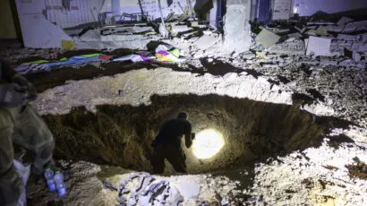 Members of Israel's Home Front Command and police forces inspect a crater left by an exploded projectile at a heavily-damaged school building in Israel's southern city of Gedera on October 1, 2024, after Iran launched a barrage of missiles at Israel in response to the killings of Lebanese Hezbollah leader Nasrallah and other Iran-backed militants. Reports said Iran fired between 150 and 200 missiles in the attack, the country's second on Israel after a missile and drone attack in April in response to a deadly Israeli air strike on the Iranian consulate in Damascus. (Photo by MENAHEM KAHANA/AFP via Getty Images)