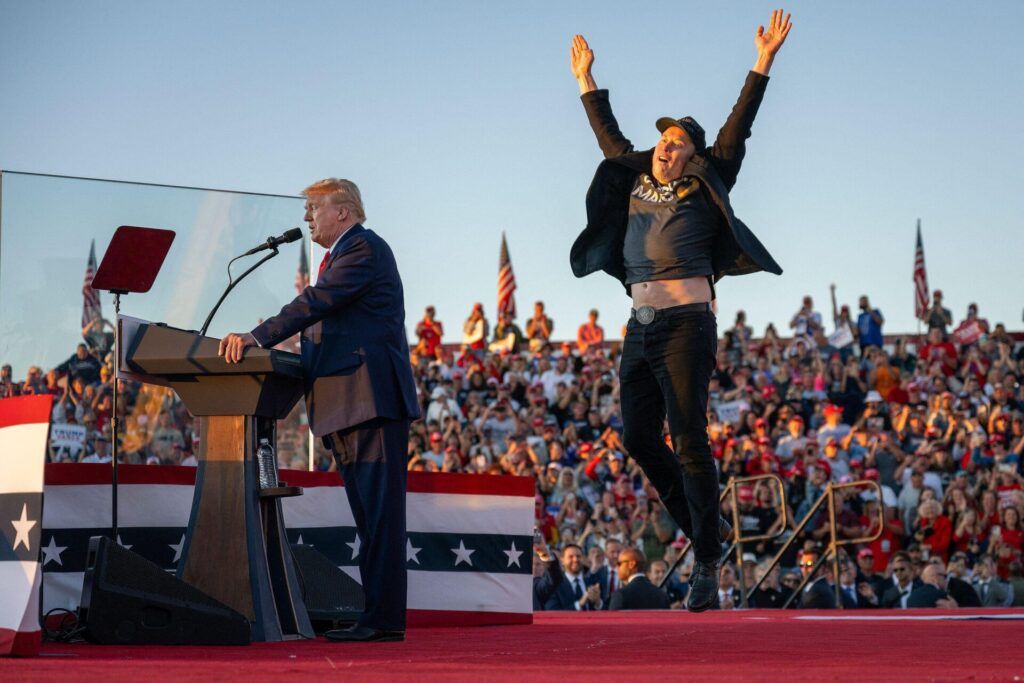 Elon musk jumping on stage at a Trump rally