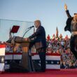 Elon musk jumping on stage at a Trump rally