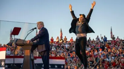 Elon musk jumping on stage at a Trump rally