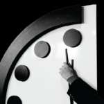 A person holds the minute hand of the Doomsday Clock at the 2024 Clock announcement.