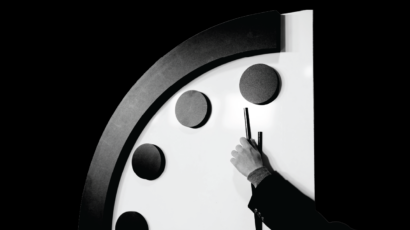 A person holds the minute hand of the Doomsday Clock at the 2024 Clock announcement.