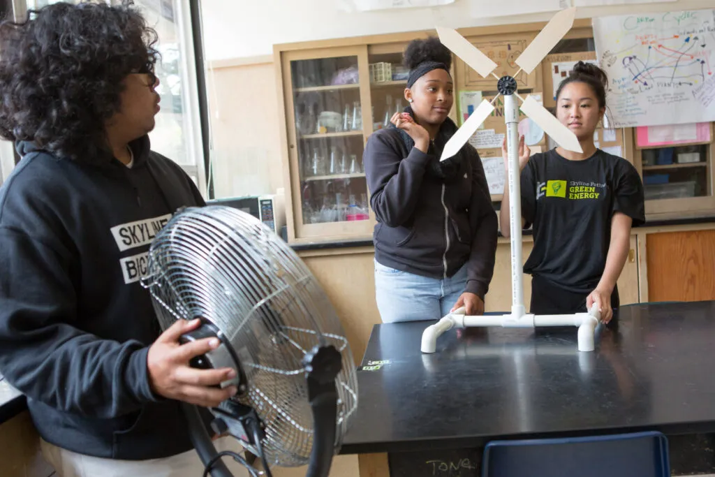 Students test a model wind turbine they constructed.