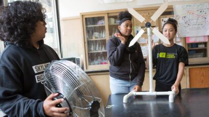 Students test a model wind turbine they constructed.