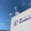 Sign with words "AI Action Summit" against a blue sky