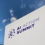 Sign with words "AI Action Summit" against a blue sky