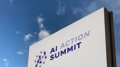 Sign with words "AI Action Summit" against a blue sky