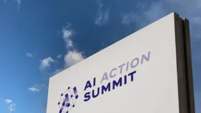 Sign with words "AI Action Summit" against a blue sky