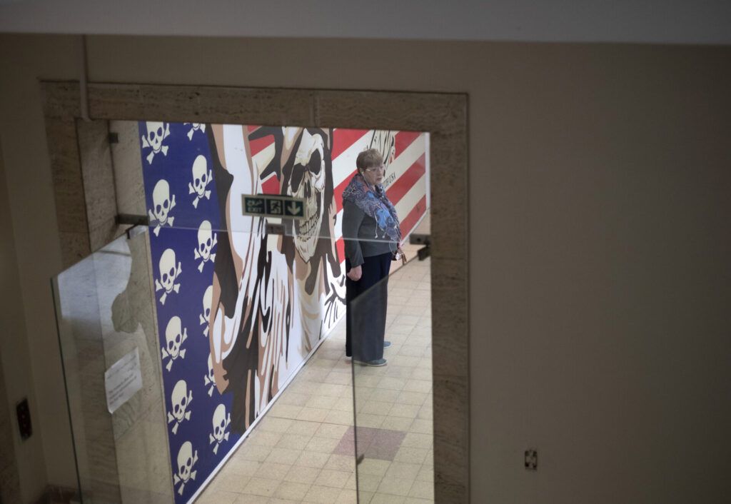 A Russian tourist stands in front of an anti-U.S. mural as she visits the former U.S. embassy in downtown Tehran, Iran, on April 12—the day of the Iran-U.S. nuclear discussions. (Photo by Morteza Nikoubazl/NurPhoto via Getty Images)