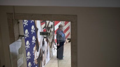 A Russian tourist stands in front of an anti-U.S. mural as she visits the former U.S. embassy in downtown Tehran, Iran, on April 12—the day of the Iran-U.S. nuclear discussions. (Photo by Morteza Nikoubazl/NurPhoto via Getty Images)