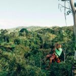 man on zipline in front of jungle