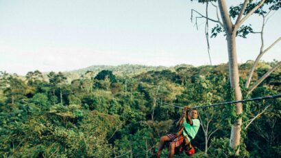 man on zipline in front of jungle