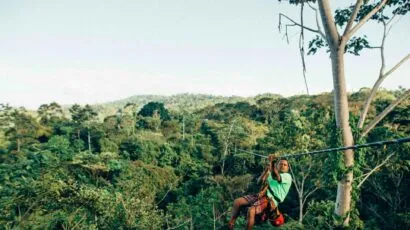 man on zipline in front of jungle
