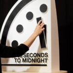 Alexandra Bell moves the hand of the Doomsday Clock