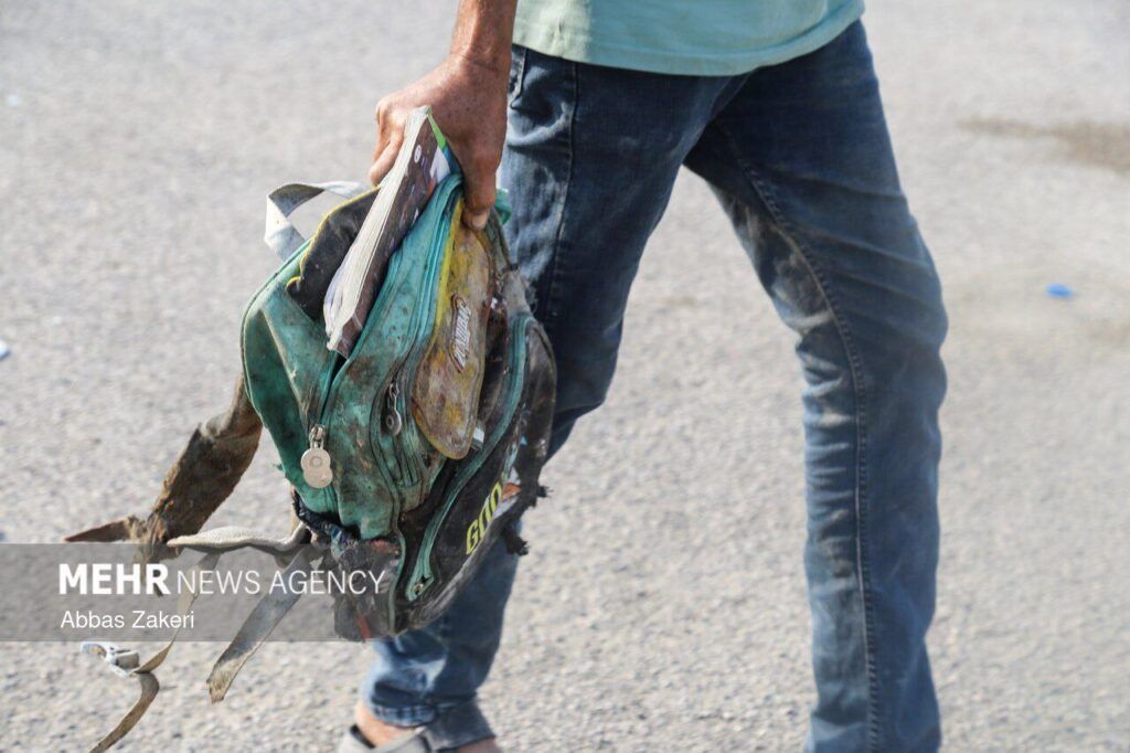 A man holding a backpack after the bombing of a school in southern Iran