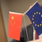 A Chinese and a European flag stand on a table. (Photo by Johannes Neudecker/picture alliance via Getty Images)