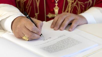Pope Leo's hands while signing his first encyclical