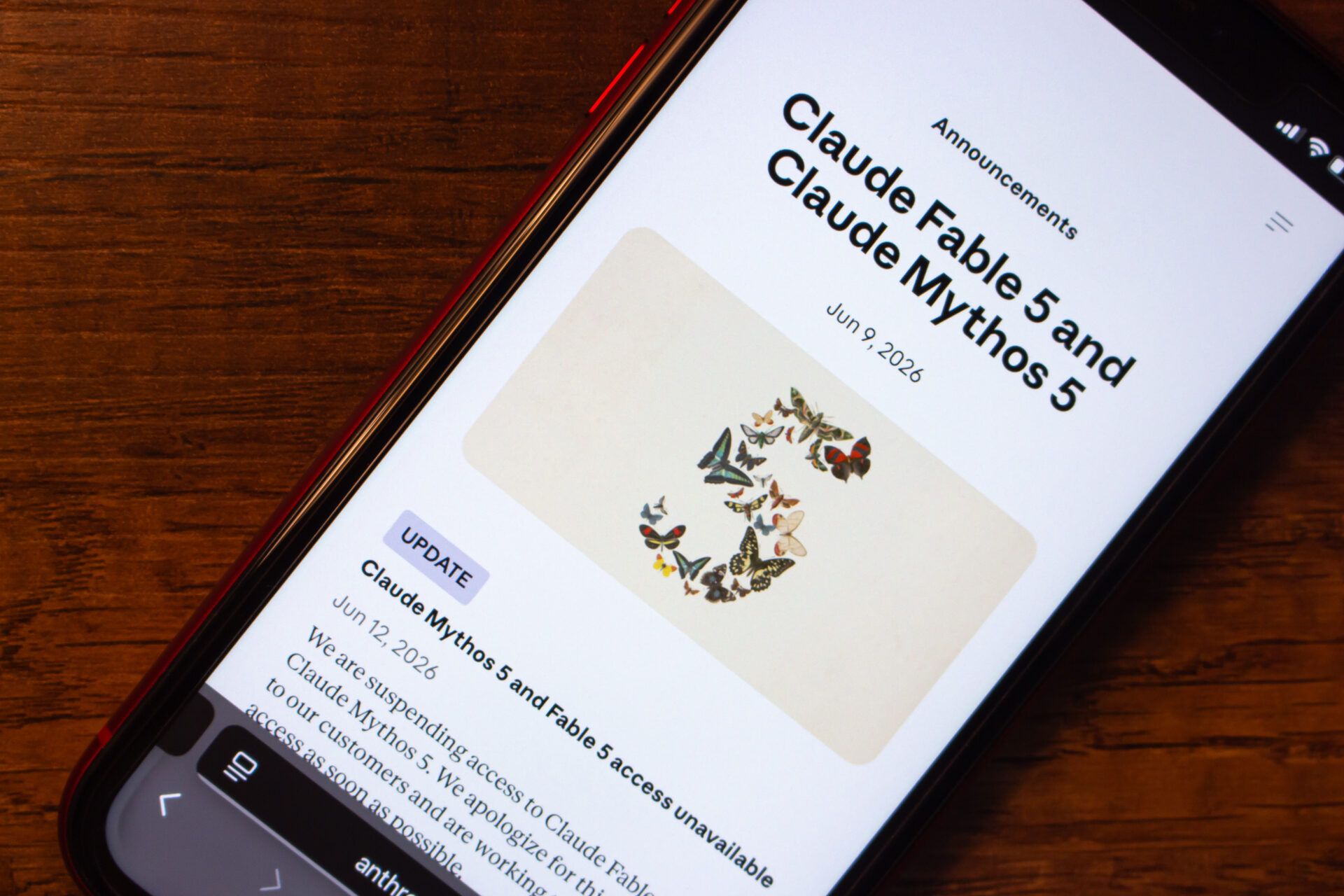 AdobeStock_2062580178_Editorial_Use_Only Smartphone showing an Anthropic announcement page for Claude Fable 5 and Claude Mythos 5 with update notice suspending access to both AI models.