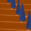 A series of blue cones arranged in a diagonal line on a textured orange surface with horizontal grid lines.