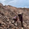 two people performing hard labor in a cobalt mine