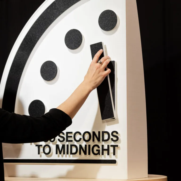 Alexandra Bell moves the hand of the Doomsday Clock