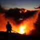 firefighter in silhouette with multiple fires in background